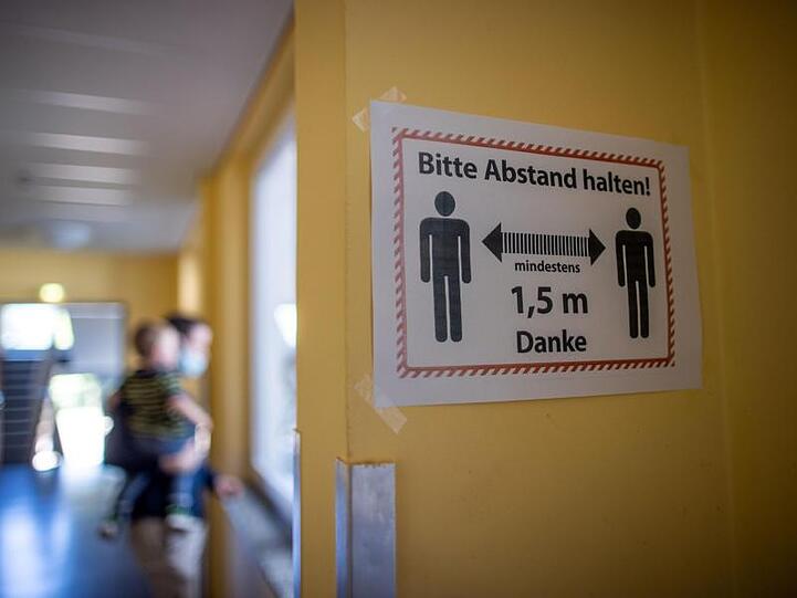 Ein Hinweisschild auf die Sicherheitsabstände hängt in einem Schulflur der Grundschule Lankow.