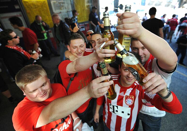 Anstoßen auf ihr Team: Die Bayern-Fans machen sich gut gelaunt auf den Weg ins Stadion. Die Bilder aus der Fußball-Stadt zum Durchklicken!