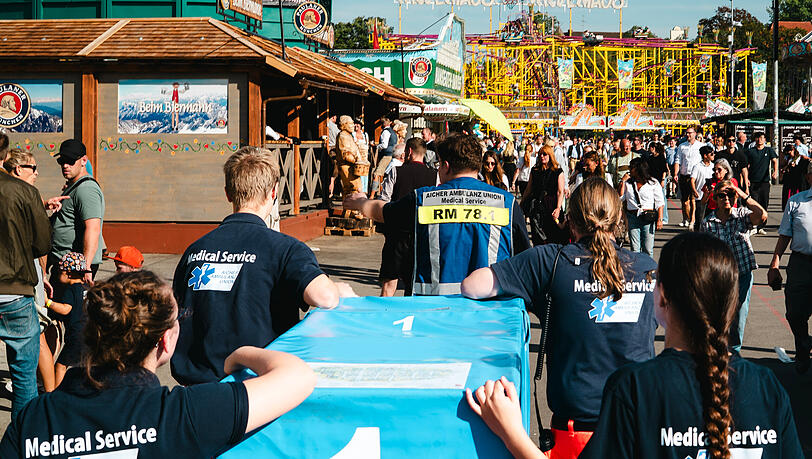 Hunderte Patientinnen und Patienten versorgen die ehrenamtlichen Helferteams der Aicher Ambulanz jeden Tag auf der Wiesn. Bei ihren Eins&auml;tzen m&uuml;ssen sie sich durch die dicht gedr&auml;ngten Massen k&auml;mpfen, um zum Einsatzort zu gelangen.