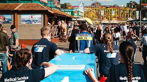 Hunderte Patientinnen und Patienten versorgen die ehrenamtlichen Helferteams der Aicher Ambulanz jeden Tag auf der Wiesn. Bei ihren Eins&auml;tzen m&uuml;ssen sie sich durch die dicht gedr&auml;ngten Massen k&auml;mpfen, um zum Einsatzort zu gelangen.