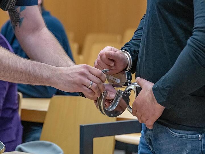 Einem Angeklagten werden im Verhandlungssaal des Landgerichts die Handschellen abgenommen. Foto: Armin Weigel