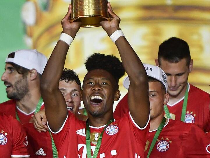 Münchens David Alaba hält die Trophäe nach dem Spiel hoch. Foto: John Macdougall/AFP/POOL/dpa