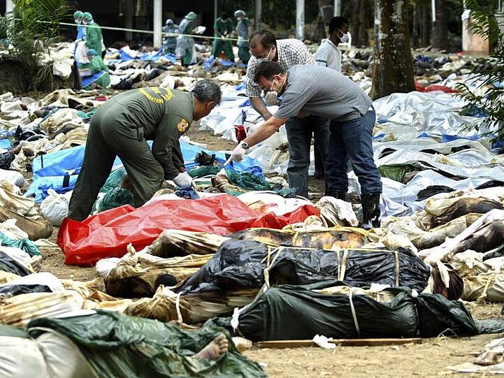 Zwei Männer suchen unter den Opfern von Khao Lak nach Verwandten.