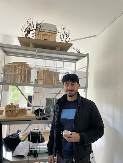 Can Çiçek vor Modellen, die er im Studium gebaut hat.