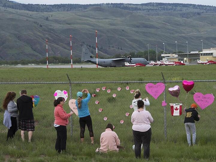 Gedenken am Zaun - im Hintergrund sind Flugzeuge der kanadischen Kunstflugstaffel "Snowbirds" zu sehen.