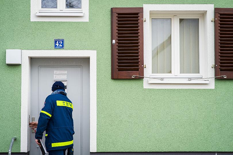 Mitarbeiter vom Roten Kreuz und vom Technischen Hilfswerk kontrollieren, ob alle Anwohner ihre Häuser verlassen haben.