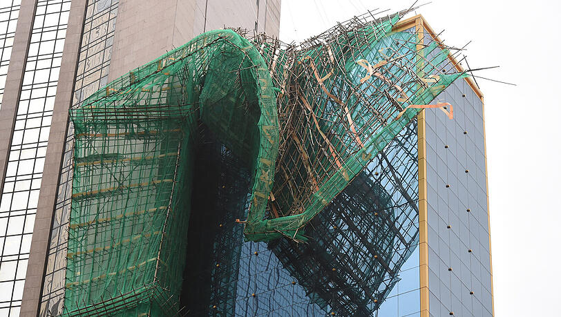 Große Teile eines Baugerüsts in Hongkong wurden durch den Sturm auf ein benachbartes Gebäude gedrückt. Große Teile eines Baugerüsts in Hongkong wurden durch den Sturm auf ein benachbartes Gebäude gedrückt.