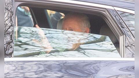 König Charles II. winkt am Freitag aus dem Auto.