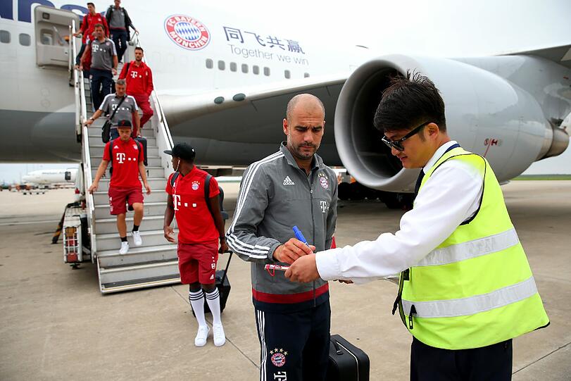 Ein Flughafenangestellter schnappte sich auch das Autogramm von Trainer Pep Guardiola.