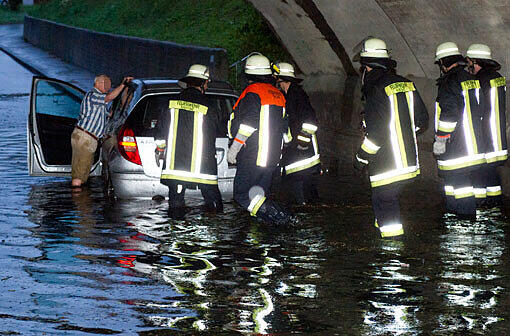 Die Feuerwehr hilft einem Autofahrer im Kreis Raisting - sein Auto ist durch die massiven Regengüsse in einer Unterführung liegen geblieben.