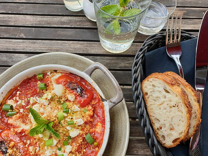 Shakshuka mit gestocktem Ei und Brot.