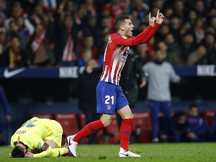 Lucas Hernandez von Atletico gestikuliert vor dem Schiedsrichter. Barcelonas Lionel Messi (l) liegt am Boden. Foto: Paul White/AP