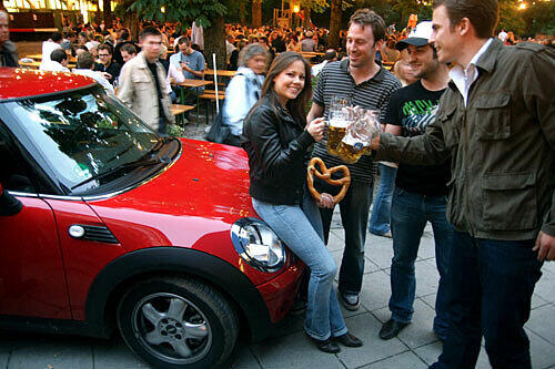 Vorjahressiegerin Maria Bieler und der MINI One werden von Tim, Peter und Milan im Biergarten des Hofbräukellers bewundert.
