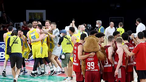 Während die Münchner Spieler enttäuscht zusammen stehen, bejubeln die Alba-Akteure den Sieg.