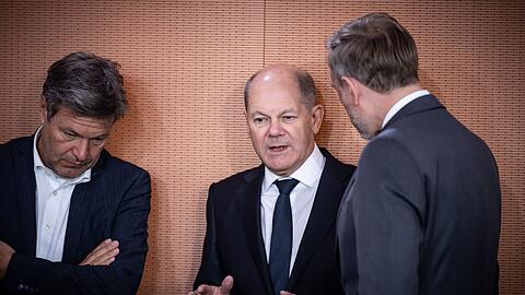 Kanzler Olaf Scholz (M) spricht mit Finanzminister Christian Lindner (r) und Wirtschaftsminister Robert Habeck.