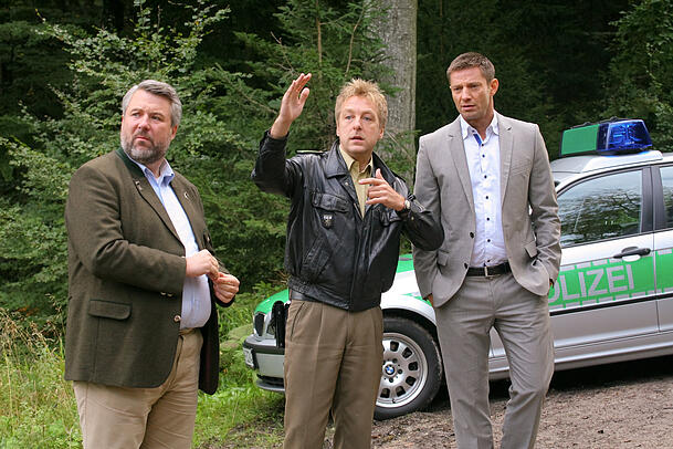 Als ein Forstbesitzer morgens tot in seinem Wald gefunden wird, ermitteln die Rosenheimer Kommissare Stadler (Dieter Fischer, l.), Hansen (Igor Jeftić, r.) und Polizist Mohr (Max Müller). Als ein Forstbesitzer morgens tot in seinem Wald gefunden wird, ermitteln die Rosenheimer Kommissare Stadler (Dieter Fischer, l.), Hansen (Igor Jeftić, r.) und Polizist Mohr (Max Müller).