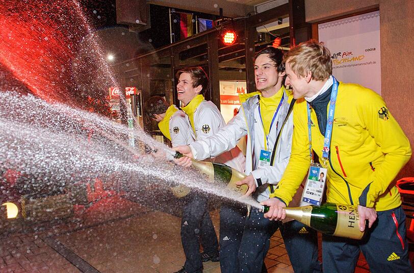Schampus Marsch! Die deutschen Skispringer Freund, Wellinger, Kraus und Wank feiern Olympiagold im Teamspringen mit einer Champagnerdusche.