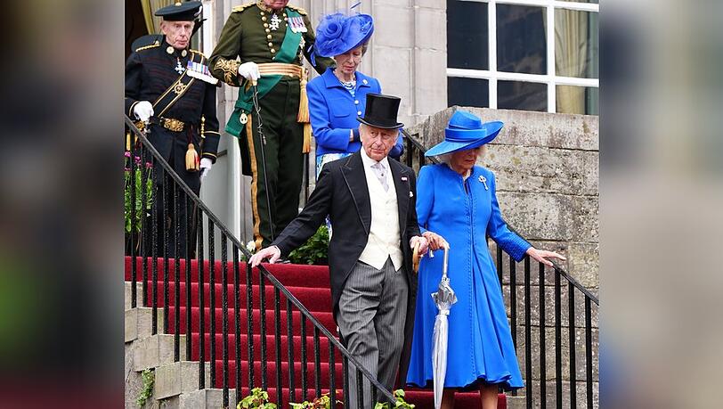 Neben Königin Camilla (r.) und Prinzessin Anne in Blau hat sich auch König Charles herausgeputzt - mit Frack und Zylinder.