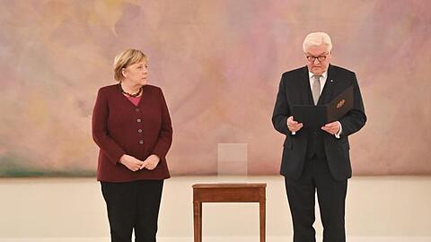 Bundespräsident Frank-Walter Steinmeier händigt Bundeskanzlerin Angela Merkel (CDU) die Entlassungsurkunde aus.