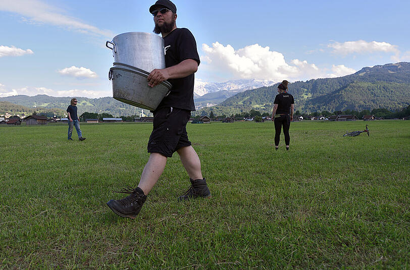 Ein G7-Gegner bringt Camping-Utensilien auf das Gelände.