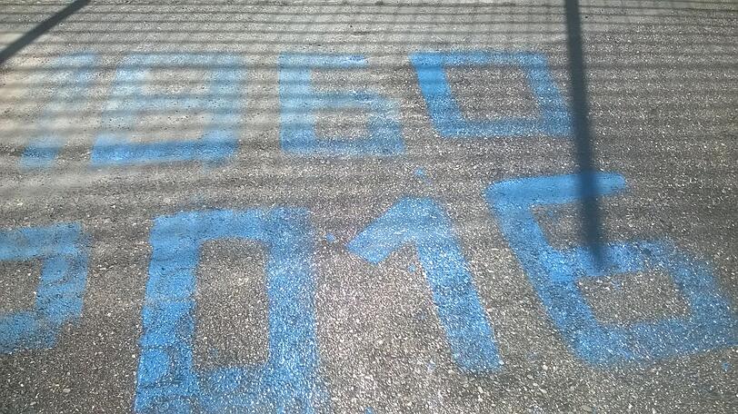 Auf dem Asphalt steht in großen blauen Lettern: "*1860, &dagger;2016".