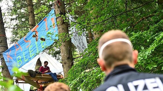 Polizisten stehen am Rande des Protestcamps im Forst Kasten nahe München. (Archivbild)