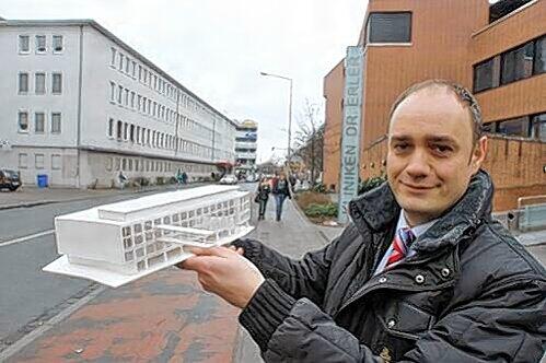 Erler-Geschäftsführer Markus Stark zeigt das Modell des Neubaus, der bis 2012 gegenüber der Klinik entstehen soll.