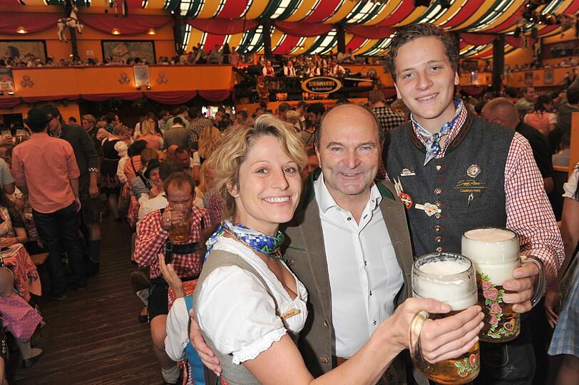Der Wirt des Hippodrom-Festzelts, Sepp Krätz (m) posiert mit der Bedienung Katrin (l) und dem Kellner Christian (r)