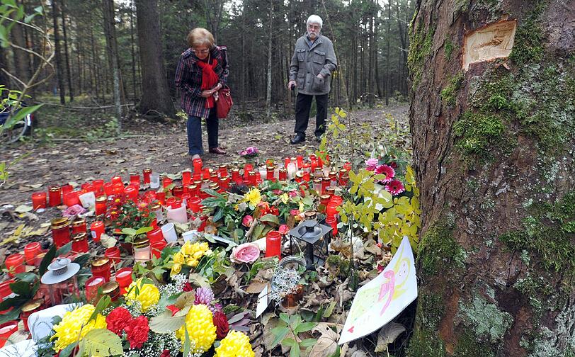 Bluumen, Kerzen und Briefe: Die Anteilnahme am Tod des Augsburger Polizisten ist groß. In der Baumkerbe rechts oben steckte eine Kugel.