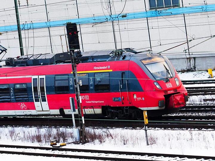 Ein Regionalzug fährt in Bamberg (Bayern) über die mit Schnee bedeckten Gleise. Foto: Nicolas Armer/Archiv