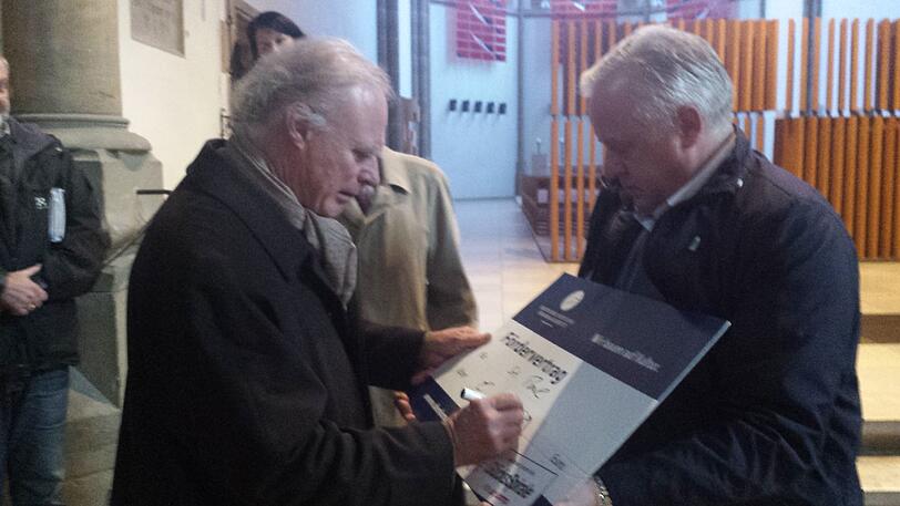 Peter-Christian von Teysen unterzeichnet den Scheck für Pfarrer Stanislaus Dorawa.	Foto: Jessen