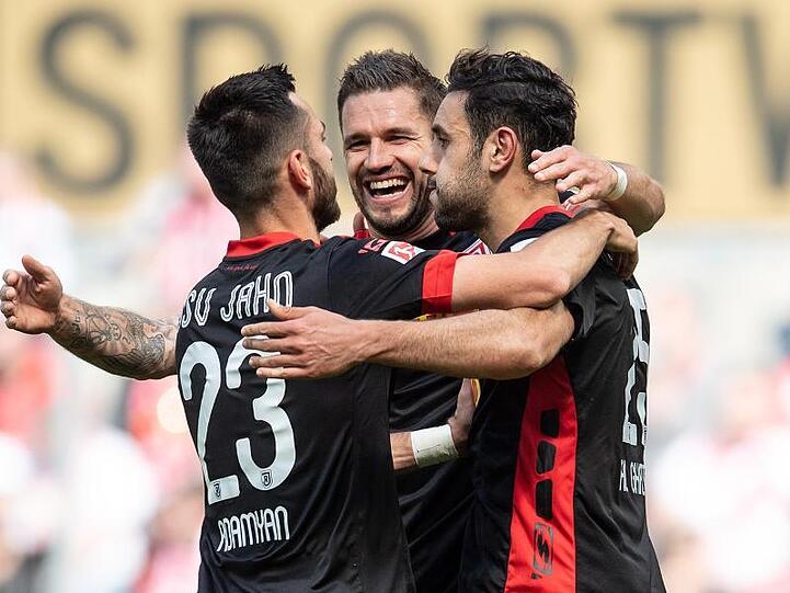 Regensburgs Sargis Adamjan (l-r), Marco Grüttner und Hamadi Al Ghaddioui jubeln nach dem dem Treffer zur 3:0 Führung. Foto: Marius Becker