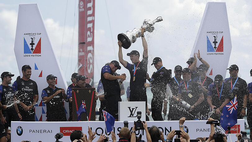 Team New Zealand Steuermann Peter Burling hält in Hamilton den Pokal des America's Cup, während er sich mit seinen Teamkollegen feiern lässt.