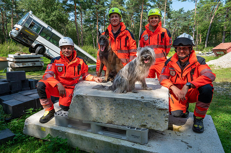 Eric Weiler (l-r), Christian Raupp, Andrea Sauer und Fabian Puchelt von der Rettungshundestaffel der Freiwilligen Feuerwehr Hochbrück und ihre Hunde Benji (l), ein Belgischer Schäferhund (Malinois), sechs Monate alt, und Paula, ein Pyrenäenschäferhund (Berger des Pyrénées), acht Monate alt.