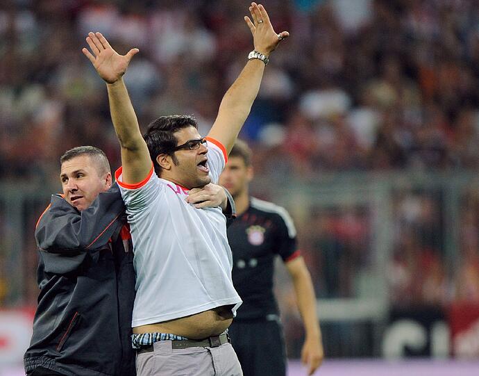 Er rennt in der 55. Minute auf den Platz und sorgt kurz für Aufsehen: Der Bayern-Fan und Flitzer wird von den Sicherheitskräften aber schnell gestellt.