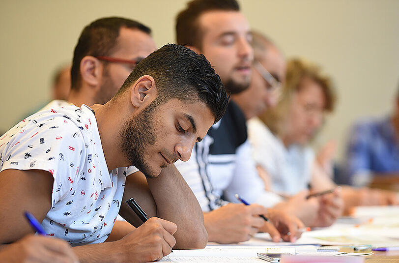 Flüchtlinge in einem Deutschkurs. Da sich viele der Neuankömmlinge die Fahrt zum Kurs nicht leisten können, wirbt die Bayreuther Universität jetzt für Spenden. (Archivbild)