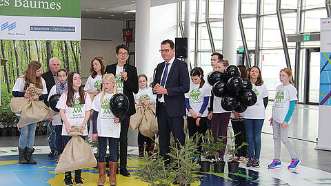 Felix Finkbeiner (mit Mikrofon) und Bundesminister Gerd Müller mit Schülern einer Münchner Umweltschule. Die jungen Bäume sollen in der Nähe des Messegeländes eingepflanzt werden.