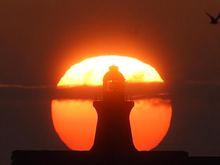 Sonnenaufgang im August hinter dem South Shields Leuchtturm an der Mündung des Tyne in Großbritannien.