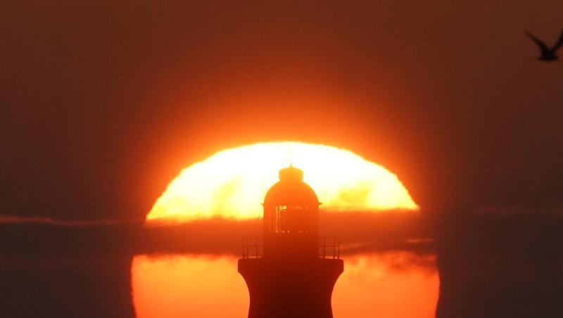 Sonnenaufgang im August hinter dem South Shields Leuchtturm an der Mündung des Tyne in Großbritannien. Sonnenaufgang im August hinter dem South Shields Leuchtturm an der Mündung des Tyne in Großbritannien.