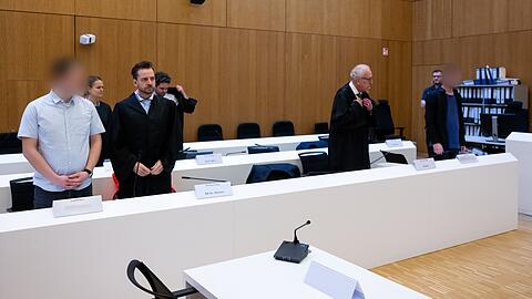 Die Angeklagten (links und rechts) stehen im Gerichtssaal neben ihren Rechtsanwälten. (Archivbild)
