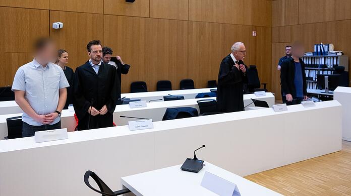 Die Angeklagten (links und rechts) stehen im Gerichtssaal neben ihren Rechtsanwälten. (Archivbild)