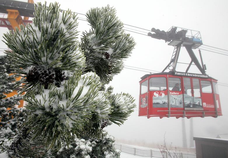 Eine Gondel der Fichtelberg-Schwebebahn faehrt am Samstag hinter verschneiten Zweigen auf dem Fichtelberg in Oberwiesenthal.