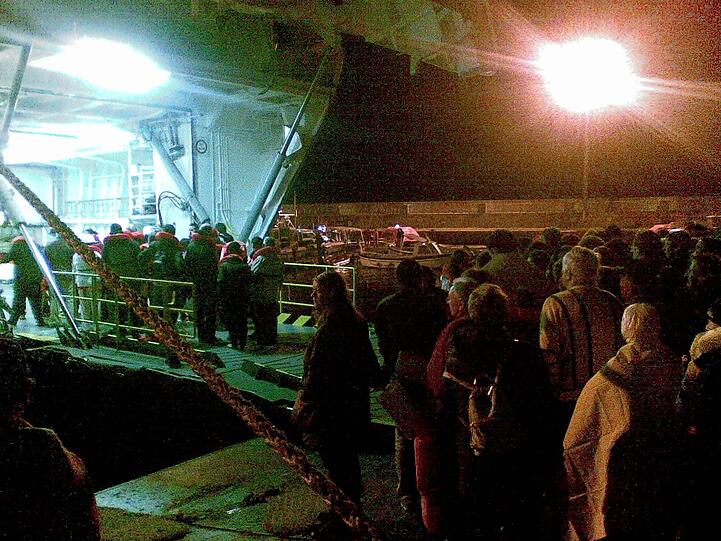 Passagiere des Kreuzfahrtschiffes «Costa Concordia» stehen nach ihrer Rettung mit Decken und Rettungswesten in der Nacht zum Samstag (14.01.2012) vor der toskanischen Küste auf der italienischen Insel Giglio auf einem Kai.