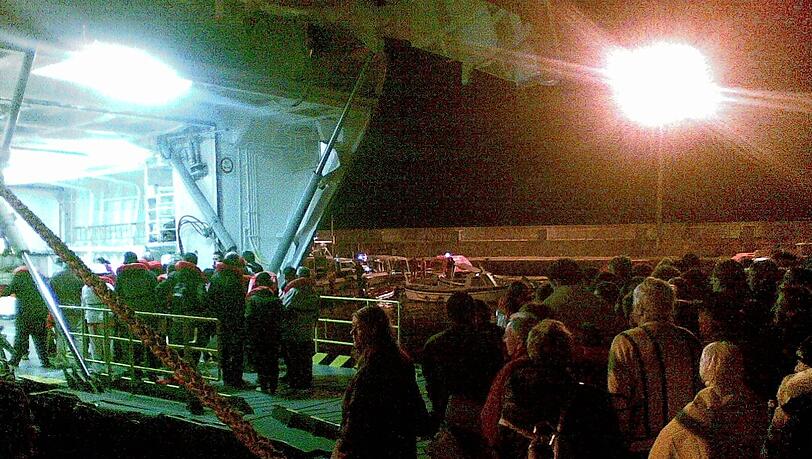 Passagiere des Kreuzfahrtschiffes «Costa Concordia» stehen nach ihrer Rettung mit Decken und Rettungswesten in der Nacht zum Samstag (14.01.2012) vor der toskanischen Küste auf der italienischen Insel Giglio auf einem Kai. Passagiere des Kreuzfahrtschiffes «Costa Concordia» stehen nach ihrer Rettung mit Decken und Rettungswesten in der Nacht zum Samstag (14.01.2012) vor der toskanischen Küste auf der italienischen Insel Giglio auf einem Kai.