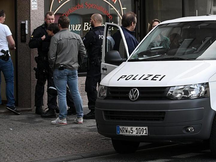 Polizeibeamte stehen vor einem Haus in der Josef-Schregel-Straße in Düren, das wegen Terrorverdachts durchsucht wird.