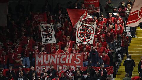 Fans auf im Gr&uuml;nwalder Stadion beim Spiel Bayern II gegen die SpVgg Unterhaching zeigen Transparente mit L&ouml;wen im Fadenkreuz.
