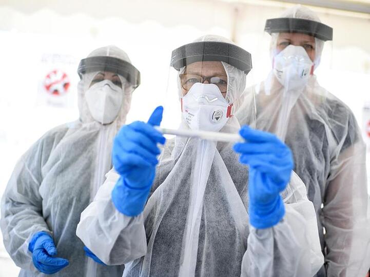 Mitarbeiter vom Gesundheitsamt in Mitte stehen auf dem zentralen Festplatz in der ambulanten Corona-Test-Einrichtung.