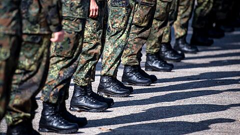 Bundeswehrsoldaten stehen auf einem Platz.