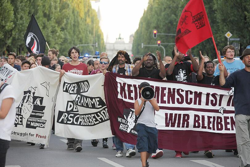 Mit Plakaten und Fahnen zogen die Flüchtlinge und ihre Unterstützer durch München.