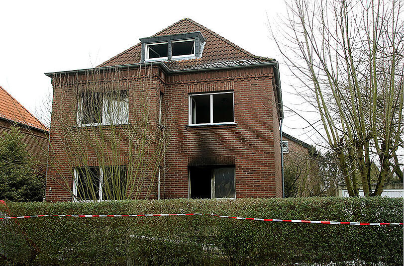 Das Haus, in dem es brannte am Morgen danach. Die Fenster sind schwarz vom Ruß.